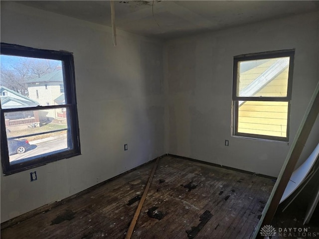 empty room with a wealth of natural light and dark wood-style floors