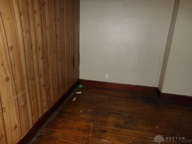 1911 Casper Ave, Middletown, OH 45042 - spare room featuring baseboards, dark wood finished floors, and wood walls