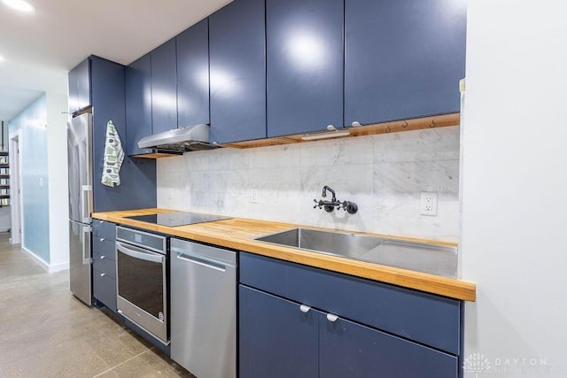 kitchen featuring tasteful backsplash, a sink, stainless steel appliances, blue cabinetry, and under cabinet range hood