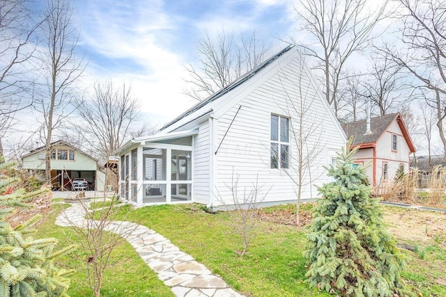 rear view of property featuring a sunroom and a yard