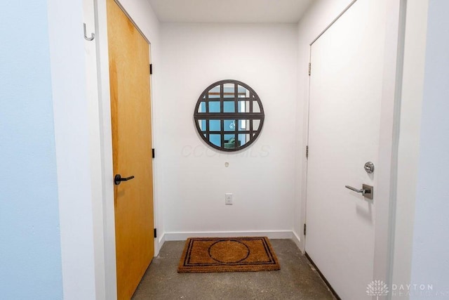 entryway with baseboards and concrete floors