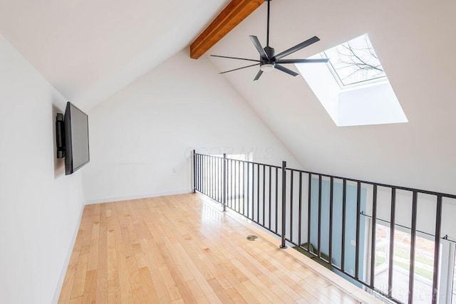 additional living space featuring vaulted ceiling with skylight, wood finished floors, and ceiling fan
