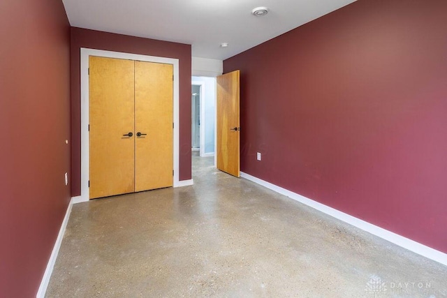 unfurnished bedroom with baseboards and a closet