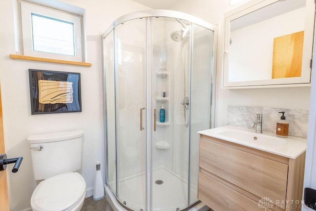 bathroom featuring backsplash, toilet, vanity, and a stall shower