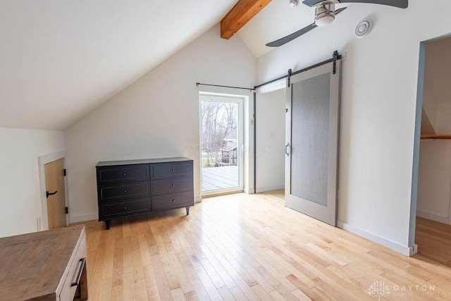 bedroom with a barn door, a ceiling fan, lofted ceiling with beams, light wood-style floors, and access to exterior