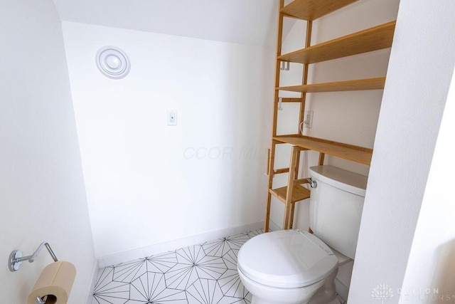bathroom with toilet and baseboards