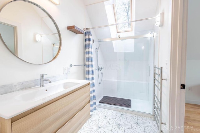 bathroom with vanity, a stall shower, visible vents, and a skylight