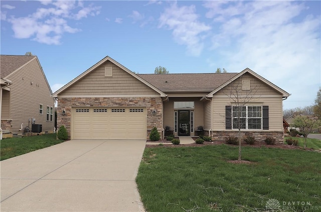 view of front of house featuring a front lawn, cooling unit, driveway, stone siding, and an attached garage