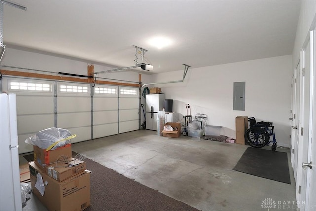 garage featuring freestanding refrigerator, electric panel, and a garage door opener
