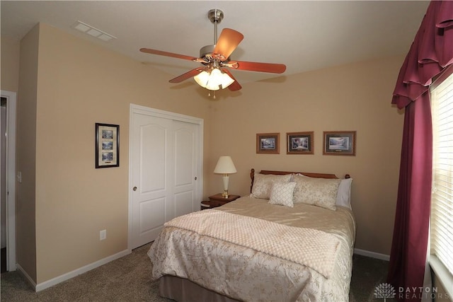 carpeted bedroom with a closet, a ceiling fan, baseboards, and visible vents