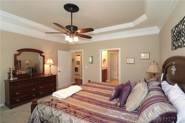 bedroom with a raised ceiling, a ceiling fan, crown molding, light colored carpet, and ensuite bathroom