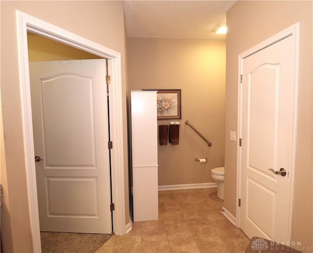 bathroom with toilet and baseboards
