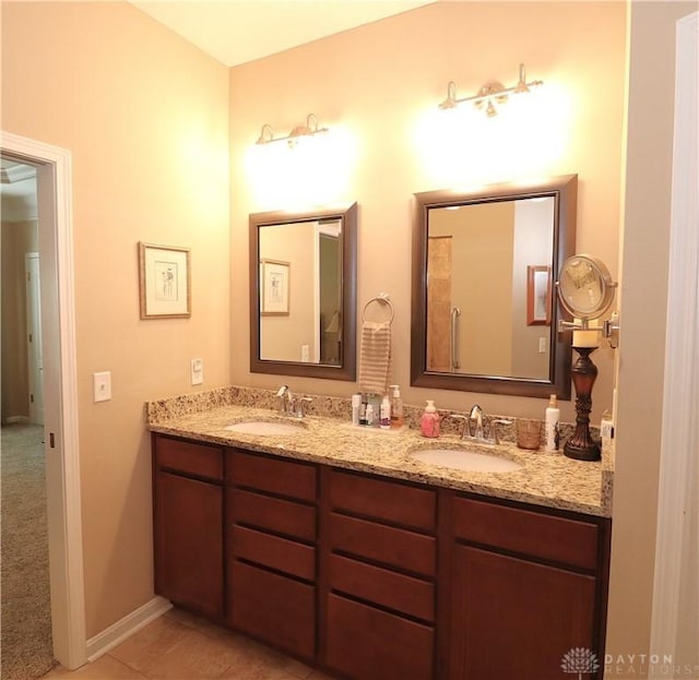 bathroom featuring double vanity, tile patterned flooring, baseboards, and a sink