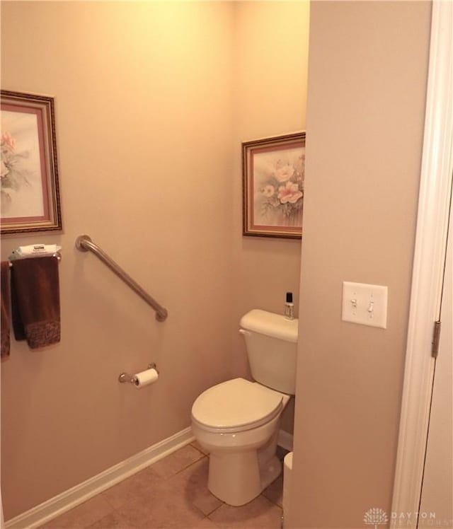 bathroom with tile patterned flooring, baseboards, and toilet