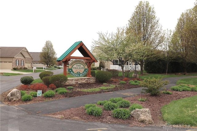 community sign featuring a residential view and driveway