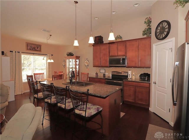 kitchen featuring a sink, stainless steel appliances, dark wood finished floors, backsplash, and visible vents