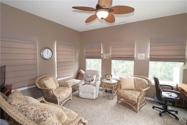 living area featuring a ceiling fan, visible vents, carpet floors, and a healthy amount of sunlight