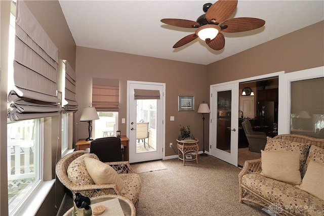 living area featuring ceiling fan, baseboards, light carpet, and french doors