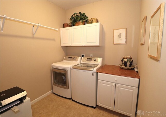 laundry room with cabinet space, independent washer and dryer, and baseboards