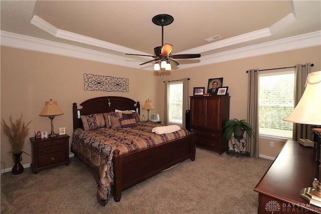 bedroom featuring visible vents, light carpet, a tray ceiling, and multiple windows