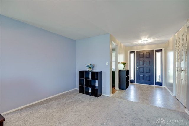 entrance foyer with baseboards and light carpet