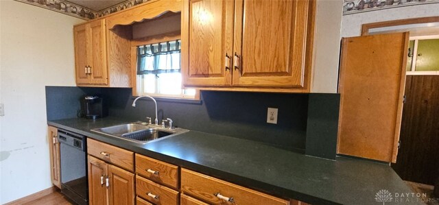 305 S Ada Doty St, Gratis, OH 45330 - kitchen featuring dishwashing machine, a sink, dark countertops, and brown cabinetry