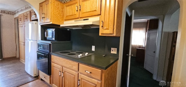 305 S Ada Doty St, Gratis, OH 45330 - kitchen with stainless steel microwave, under cabinet range hood, electric stovetop, arched walkways, and freestanding refrigerator
