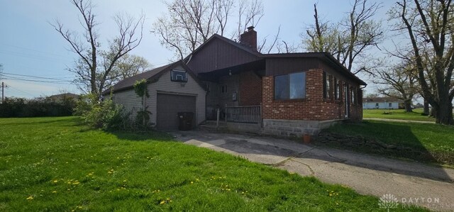 305 S Ada Doty St, Gratis, OH 45330 - bungalow with a chimney, brick siding, a garage, concrete driveway, and a front lawn