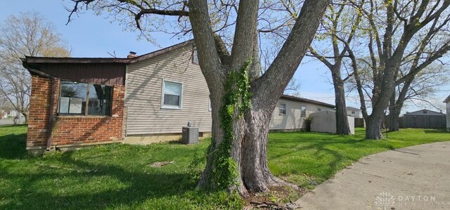 305 S Ada Doty St, Gratis, OH 45330 - view of home's exterior featuring a yard, central AC, and brick siding