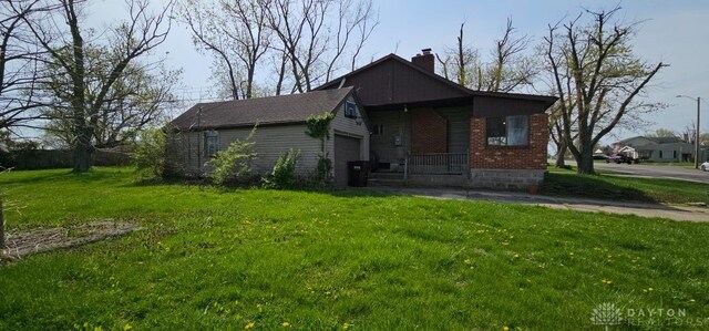 305 S Ada Doty St, Gratis, OH 45330 - bungalow-style home with a chimney, a front lawn, brick siding, and a garage
