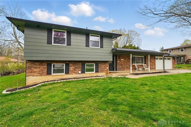 split level home featuring an attached garage, brick siding, a porch, and a front lawn