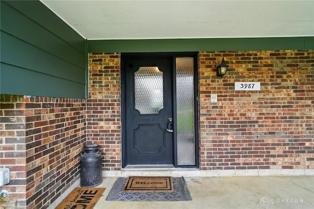 doorway to property with brick siding