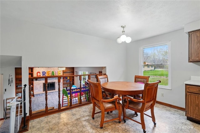 dining room featuring a fireplace, baseboards, and light floors