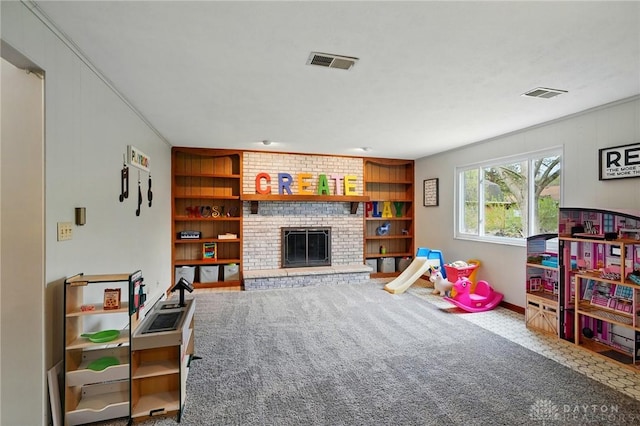 game room featuring baseboards, visible vents, a fireplace, and built in shelves