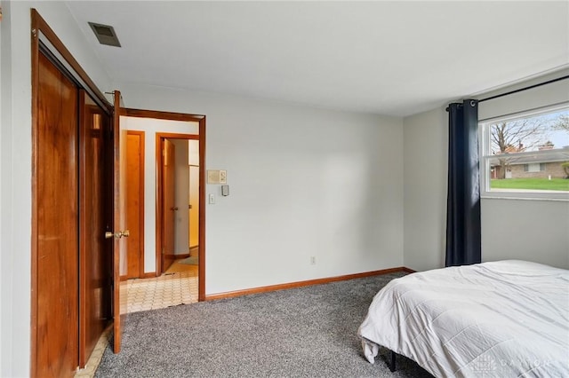 carpeted bedroom featuring baseboards and visible vents