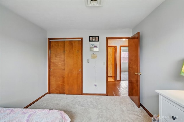 bedroom with baseboards, a closet, visible vents, and carpet
