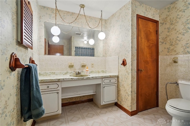 bathroom with tile patterned floors, wallpapered walls, vanity, toilet, and visible vents
