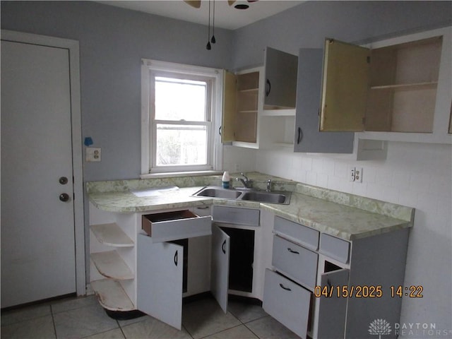 1329 Lamar Dr, Springfield, OH 45504 - kitchen with open shelves, light countertops, light tile patterned floors, and a sink