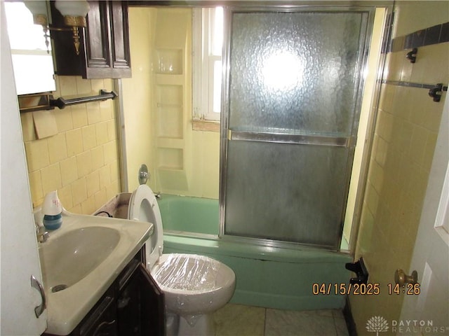 1329 Lamar Dr, Springfield, OH 45504 - full bathroom with shower / bath combination with glass door, tile patterned floors, toilet, vanity, and tile walls
