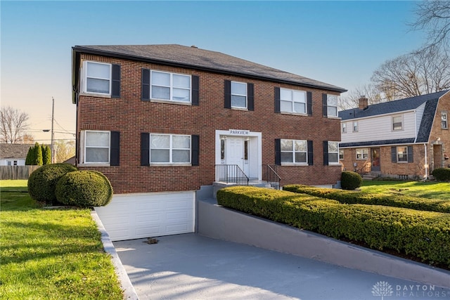 349 Orchard Dr, Oakwood, OH 45419 - colonial home with concrete driveway, an attached garage, brick siding, and a front lawn