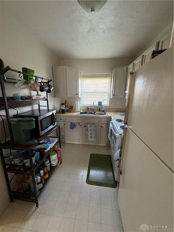 349 Orchard Dr, Oakwood, OH 45419 - kitchen featuring a textured ceiling, white appliances, and light countertops
