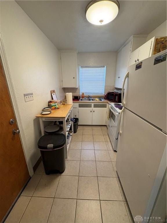349 Orchard Dr, Oakwood, OH 45419 - kitchen featuring light tile patterned flooring, white cabinetry, a sink, and white appliances