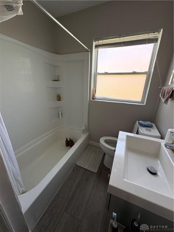 349 Orchard Dr, Oakwood, OH 45419 - bathroom with shower / bathtub combination with curtain, wood finished floors, toilet, vanity, and baseboards