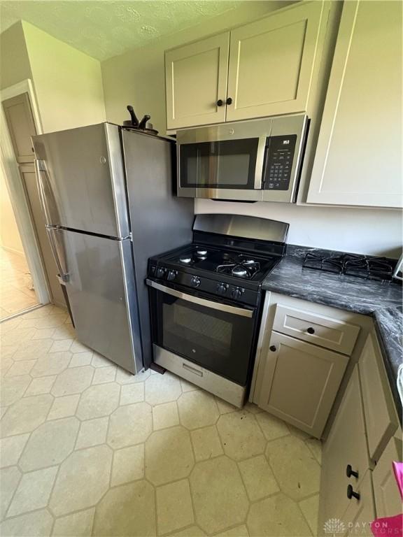 349 Orchard Dr, Oakwood, OH 45419 - kitchen with light tile patterned floors, a textured ceiling, and appliances with stainless steel finishes
