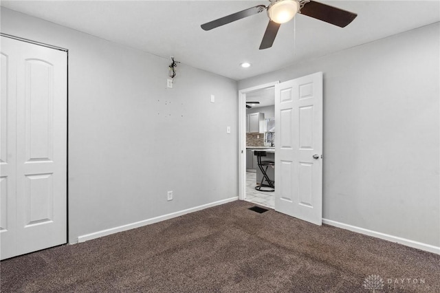 unfurnished bedroom with baseboards, a ceiling fan, carpet flooring, and visible vents