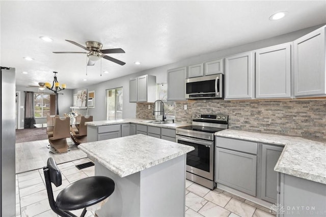 kitchen featuring light countertops, appliances with stainless steel finishes, gray cabinetry, and a sink