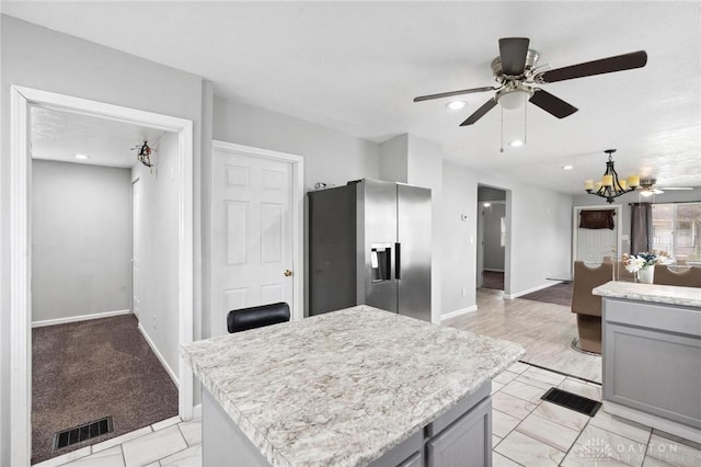 kitchen featuring stainless steel fridge with ice dispenser, light countertops, visible vents, baseboards, and gray cabinetry