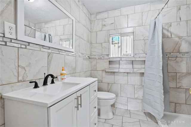 bathroom featuring tile walls, vanity, toilet, and tiled shower
