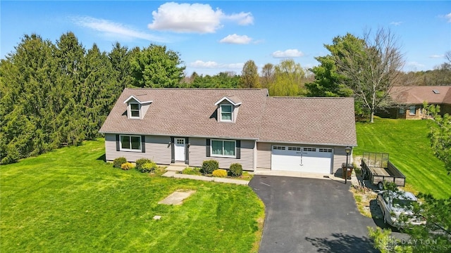 cape cod home featuring a front lawn, aphalt driveway, and a garage
