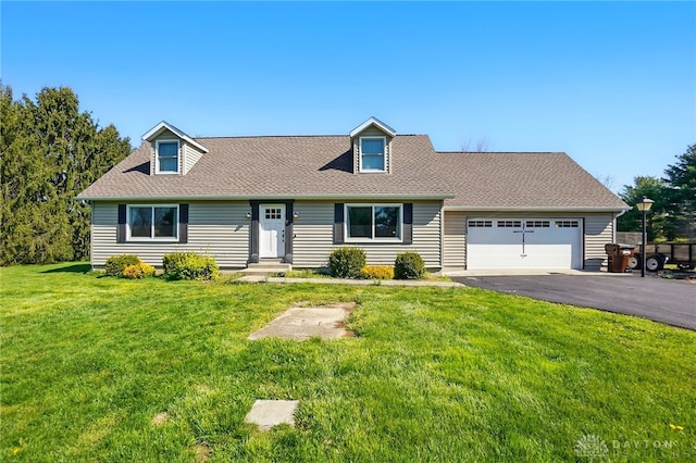 new england style home featuring a garage, driveway, a front lawn, and roof with shingles